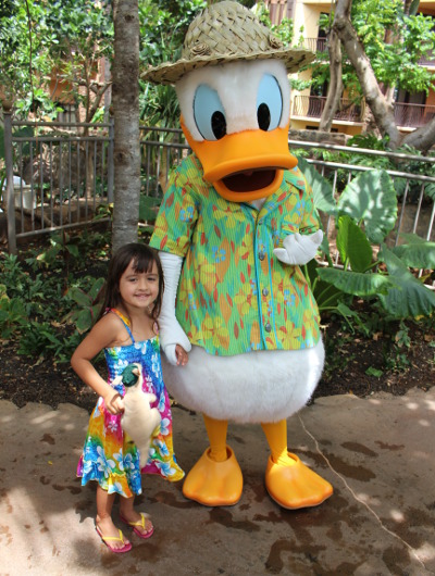 A little girl poses with the Donald Duck character at Aulani, A Disney Resort & Spa