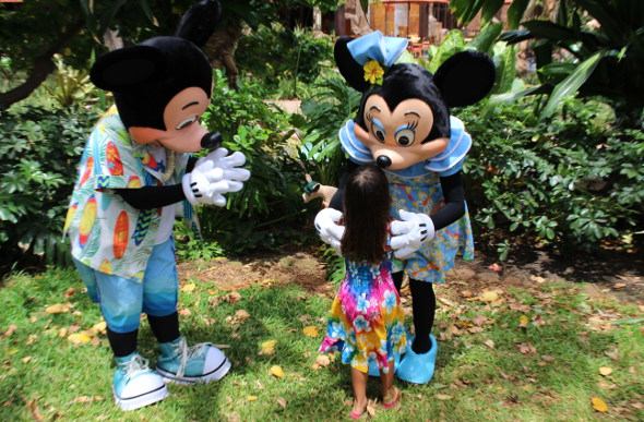 A little girl embraces Mickey and Minnie characters at Aulani, A Disney Resort & Spa