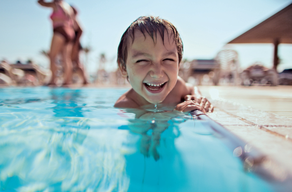 Smiling kid in pool on cruise ship