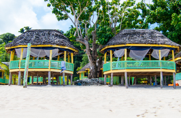 Two modest fales on the beach in Samoa