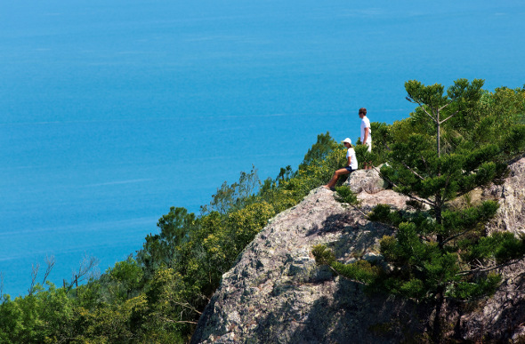  Bushwalkers rest at Passage Peak against a backdrop of blue ocean.