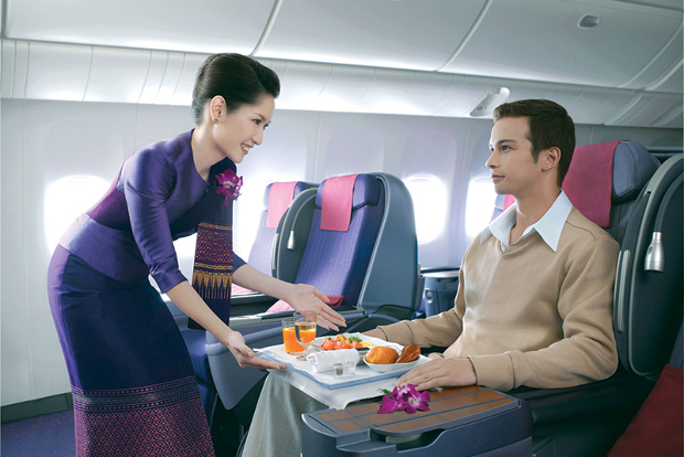 A passenger being served his meal in Thai Airways Business Class